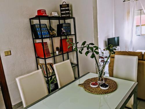 einen Esstisch mit Stühlen und ein Bücherregal in der Unterkunft Casapatrizia Appartamento compartido in Santa Cruz de Tenerife