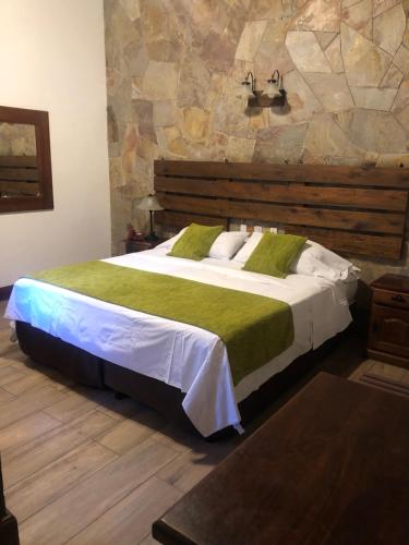 a bedroom with a large bed with a green blanket at Sissi Haz Hotel in Buenos Aires