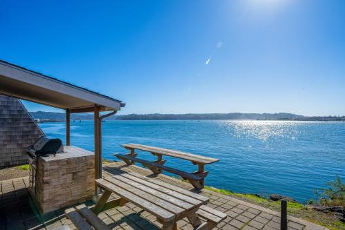 a picnic bench sitting on a deck next to the water at Beautiful Briny Retreat in Newport