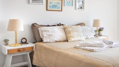 1 cama con 2 almohadas y mesita de noche con lámpara en Tu Apart en Bariloche 4 en San Carlos de Bariloche