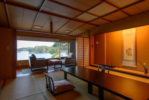 a living room with a table and a large window at Komatsu-kan Kofu-tei in Matsushima