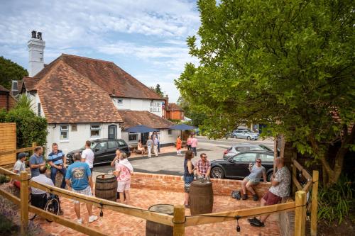 un grupo de personas parados frente a una casa en The Blue Bell en Midhurst