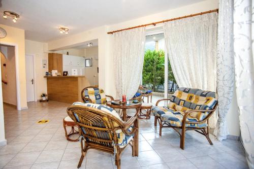 a living room with chairs and a table and a window at Captain Georgio Apartments in Poros