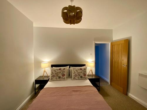 1 dormitorio con 1 cama con 2 mesitas de noche y 2 lámparas en Pillow Properties - Barnsley Centre en Barnsley
