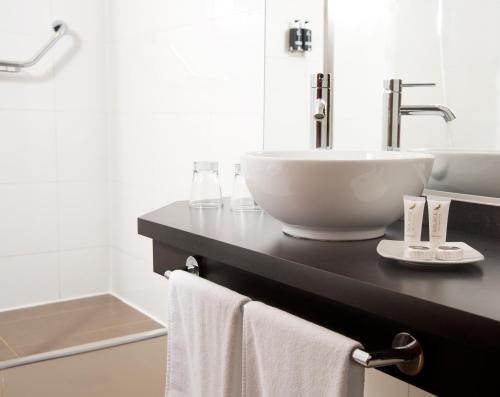 a bathroom with a sink and a counter with towels at Solace Hotel Puerto Varas in Puerto Varas