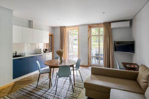 Una cocina y una sala de estar con mesa y sillas. en Už Jūrų Marių, en Juodkrantė