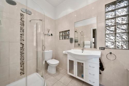 a bathroom with a toilet and a sink and a shower at Bakers Retreat in Hobart