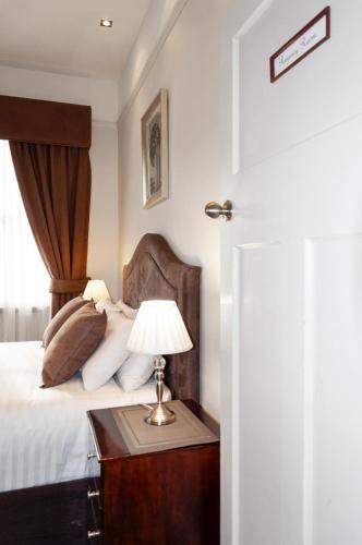 a bedroom with a bed and a table with a lamp at Bakers Retreat in Hobart