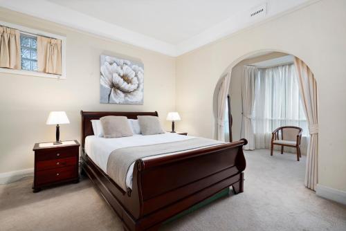 een slaapkamer met een bed, een stoel en een raam bij Bakers Retreat in Hobart