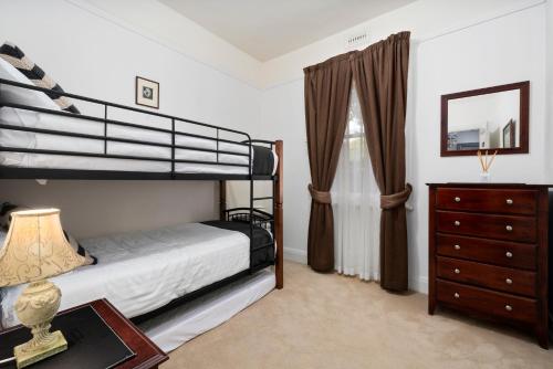 a bedroom with a bunk bed and a dresser at Bakers Retreat in Hobart