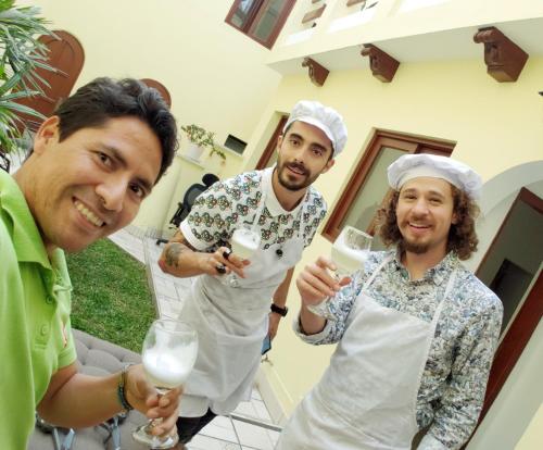 a group of three men in aprons holding wine glasses at Llaqta Wasi in Lima