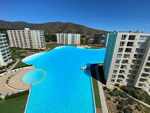 a large swimming pool in the middle of some buildings at Hermoso Departamento Papudo Laguna, 7 personas in Papudo