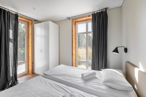 1 dormitorio con 2 camas y ventana en Už Jūrų Marių en Juodkrantė
