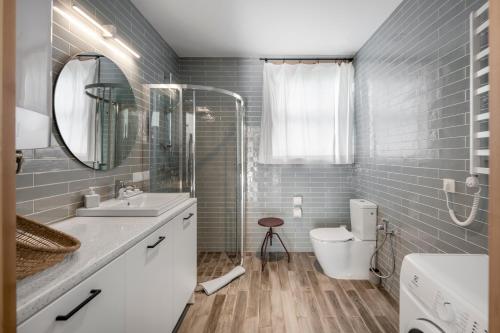 W łazience znajduje się umywalka, toaleta i lustro. w obiekcie Už Jūrų Marių w mieście Juodkrantė