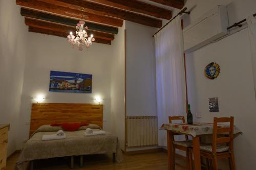a bedroom with a bed and a table and a chandelier at Ca' del Megio in Venice