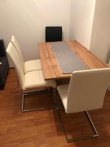 a dining room table with two white chairs and a table at Tulipános Ház in Badacsonytomaj