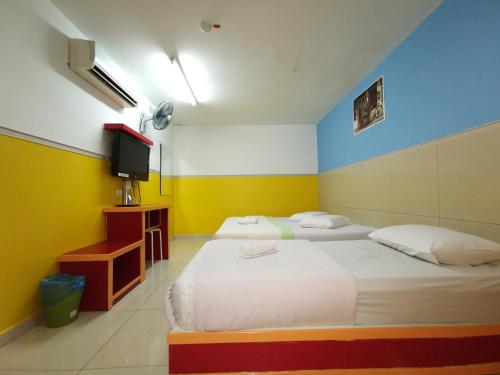 a hotel room with two beds and a tv at Hotel Abby IGB Tasek in Ipoh