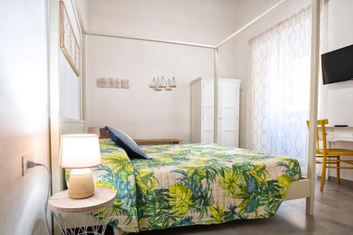 1 dormitorio con 1 cama y 1 mesa con lámpara en Piombino 1428, en Piombino