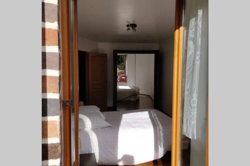 1 dormitorio con cama y espejo en le rempart, en Saint-Julien-du-Sault