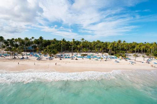 a beach filled with lots of beach chairs and umbrellas at Riu Naiboa - All Inclusive in Punta Cana