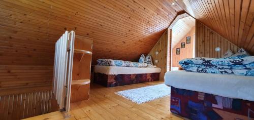 una camera da letto con due letti in una stanza di legno di Chalúpka u Babičky a Ždiar