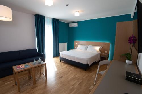 a hotel room with a bed and a couch at Principe Alogna Hotel & SPA in Altavilla Milicia