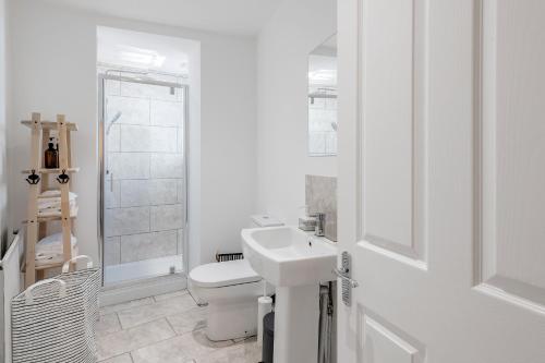 a white bathroom with a sink and a toilet at Stunning Apartment In Peaceful Central Neighbourhood, Free Private Parking in Cardiff