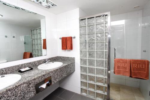 a bathroom with two sinks and a shower at Riu Naiboa - All Inclusive in Punta Cana