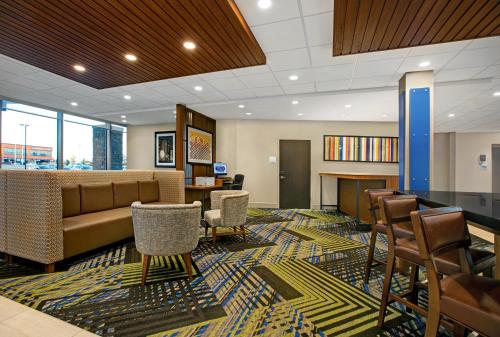 a lobby with a waiting room with a couch and chairs at Holiday Inn Express & Suites - Milwaukee - Brookfield, an IHG Hotel in Brookfield