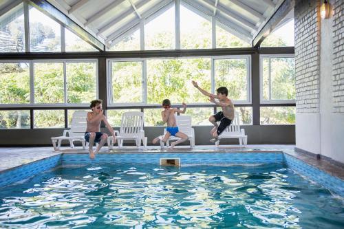 um grupo de rapazes a saltar para uma piscina em Grande Hotel Canela em Canela