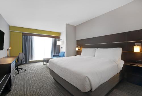a hotel room with a large bed and a desk at Holiday Inn Express & Suites - Milwaukee - Brookfield by IHG in Brookfield