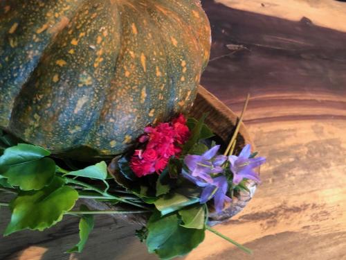 a pumpkin with flowers in a basket on a table at Casa Rural Pirineu Nevà in Nevà