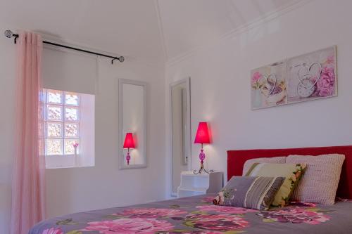 een slaapkamer met een bed, 2 lampen en een raam bij Recanto das Florenças (2) in Arco da Calheta