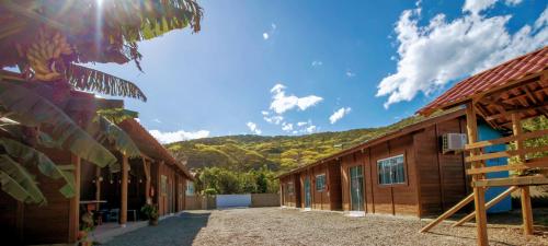 um grupo de edifícios com montanhas ao fundo em Chalés do Parque Hospedagem em Penha