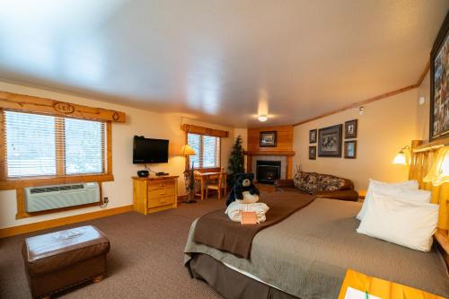 a bedroom with a large bed with a teddy bear sitting on it at Spearfish Canyon Lodge in Spearfish