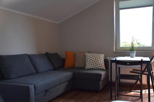 a living room with a blue couch and a table at Willa Amber Zakościele in Inowłódz