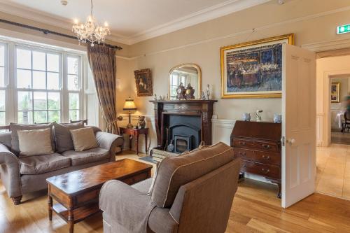 a living room filled with furniture and a fireplace at Kells Bay House and Gardens in Kells