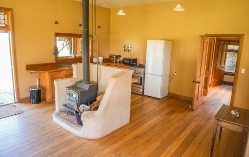 a kitchen with a fireplace in the middle of a room at The Barn Cabins & Camp in Marahau