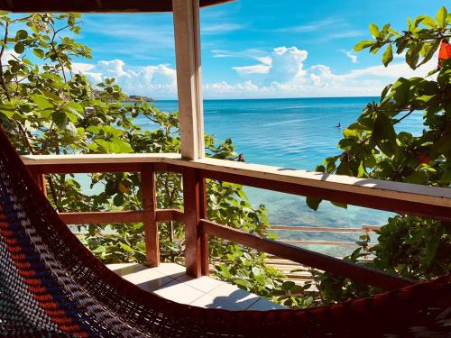 a window with a hammock looking out at the ocean at Fosters West Bay Resort in West Bay