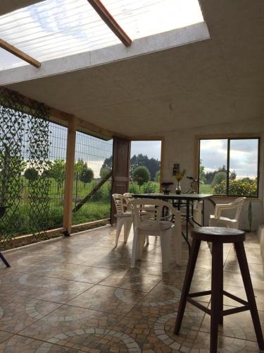 a patio with a table and chairs and windows at Parcela Kirch in Río Bueno