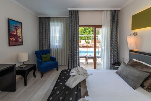 a hotel room with a bed and a blue chair at Blueberry Boutique Hotel in Fethiye
