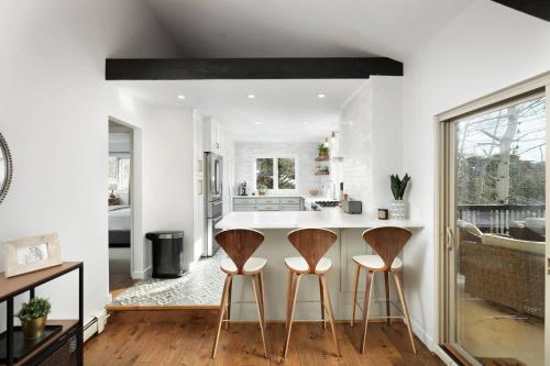 a kitchen with white walls and wooden stools at Lemond Place Home in Snowmass Village