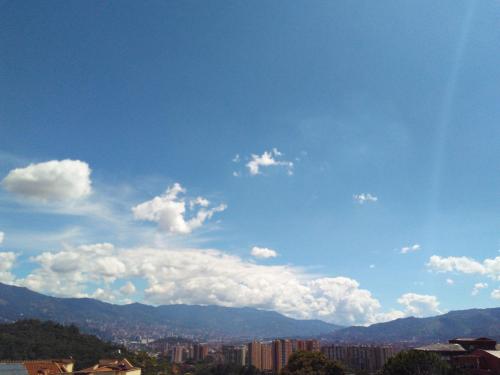 un cielo azul con nubes sobre una ciudad en APARTAMENTO MEDELLIN, en Medellín