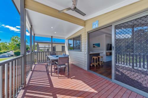 a patio with a table and chairs on a deck at Discovery Parks - Airlie Beach in Airlie Beach