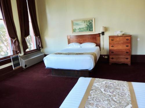 a hotel room with two beds and a dresser at The Monarch Hotel in Port Townsend