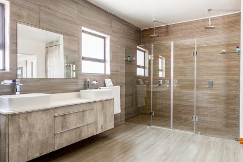 a bathroom with two sinks and a glass shower at Sagwadi Hotel in Hazyview