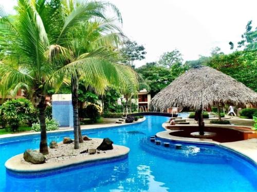 a pool at a resort with palm trees at CocoMarindo in Coco