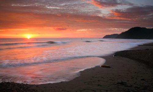 a sunset on a beach with the ocean at CocoMarindo in Coco