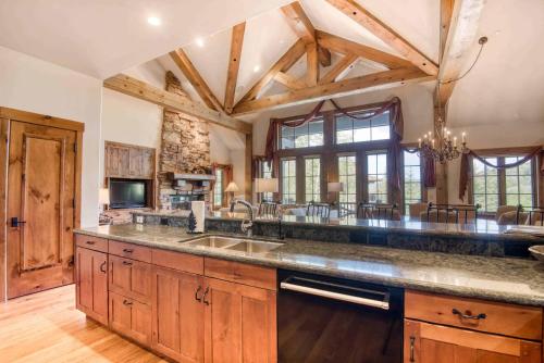 a large kitchen with wooden cabinets and a large island at Bachelor Gulch Collection by East West Hospitality in Avon