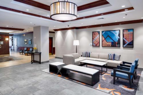 a lobby with a couch and a table and chairs at Hyatt House Boston Waltham in Waltham